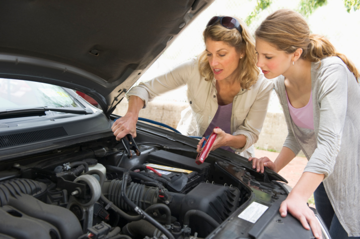 two-women-under-hood-car