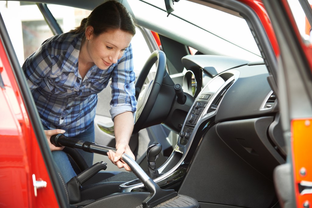 Woman using vacuum inside a car