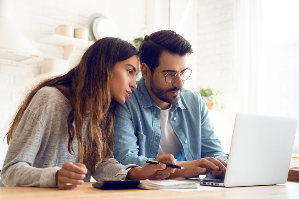 Young couple using computer for auto finances