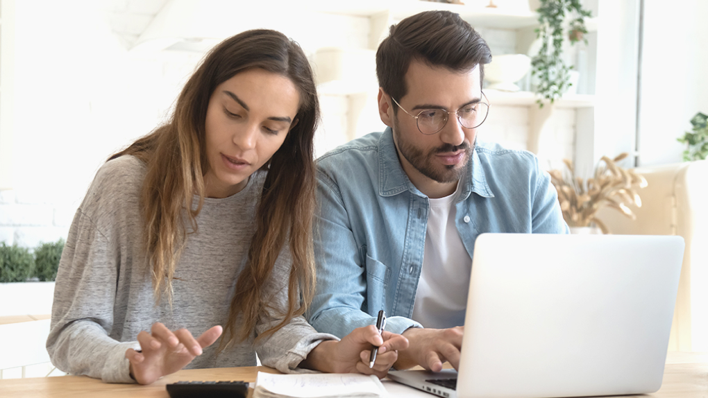 a couple doing calculations on a laptop