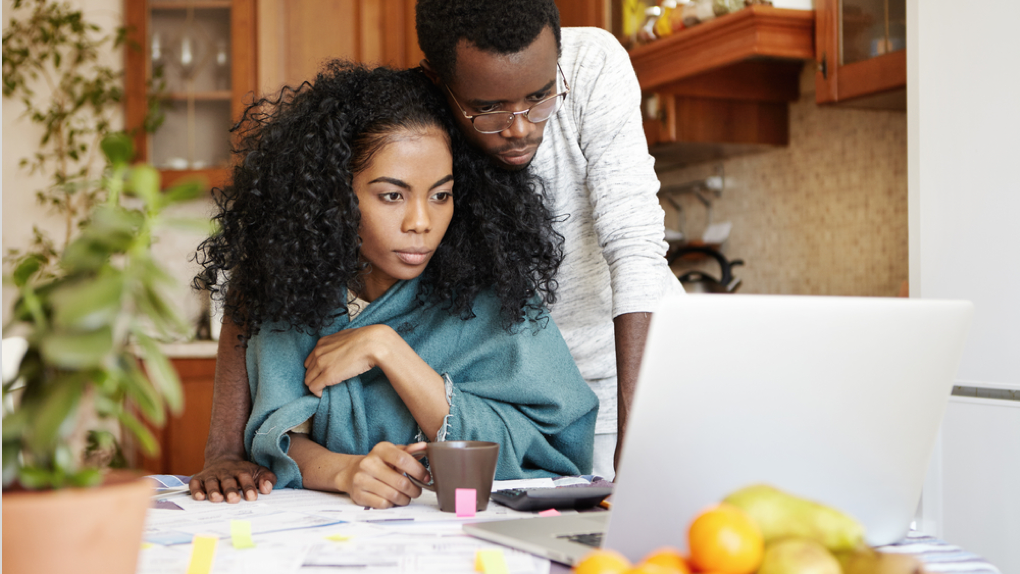 a couple doing calculations on a laptop