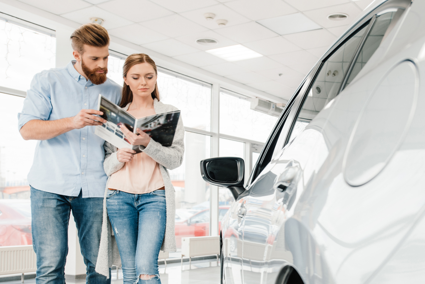 Young car shoppers beside car