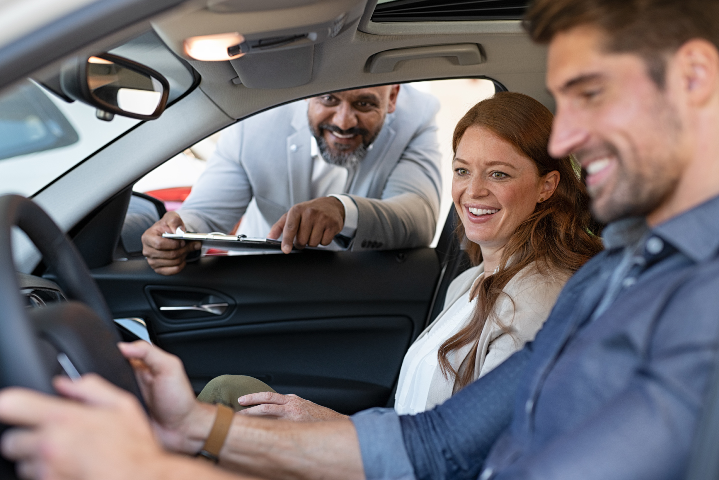 Man and woman in car at dealership