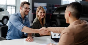 Man shaking hands with car dealer