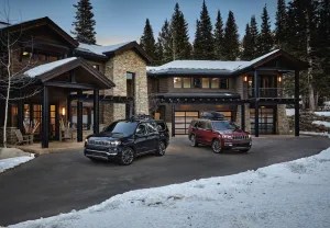 Two Wagoneer SUVs outside a skiing lodge among mountains