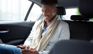 Man prequalifying for auto financing on mobile phone in a car